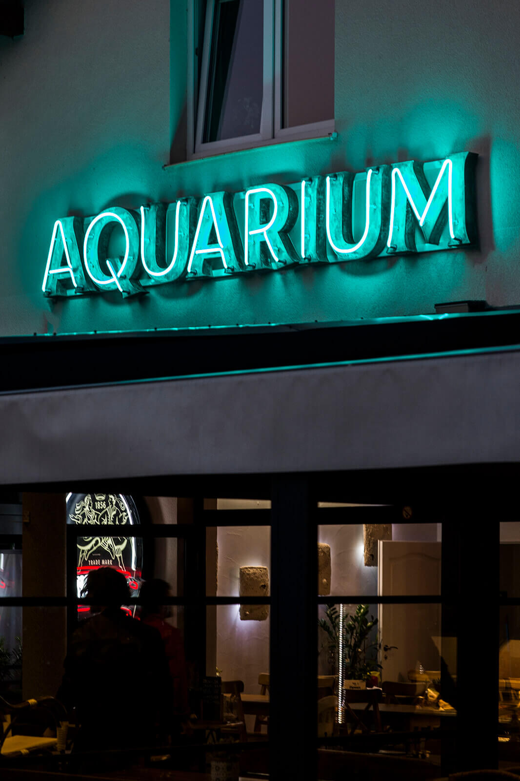 Aquarium Aquarium - Aquarium-Neon an der Gebäudewand-Buchstaben-überdachter-Patina-Neon-über-dem-Eingang-zum-Restaurant-grünes-Neon-an-der-Gebäudewand-Neon-an-einer-Säule-unter-Glas (31) 